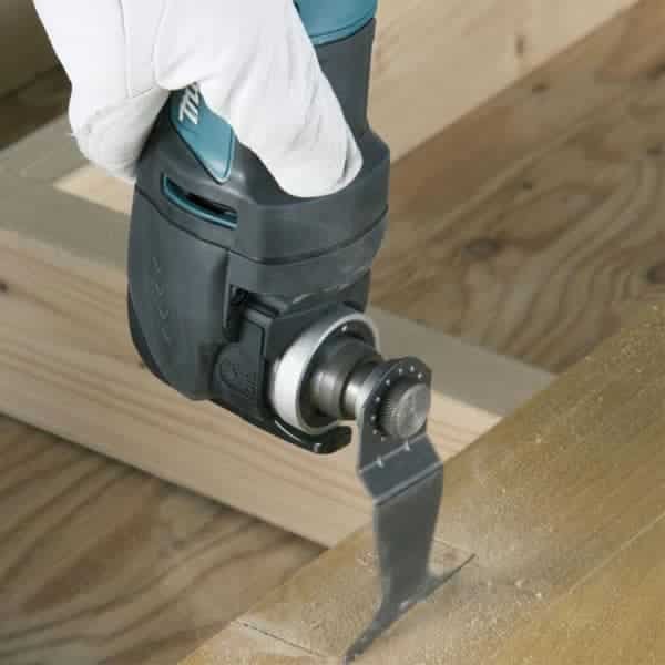 A Makita oscillating multi tool being used to plunge cut into wood