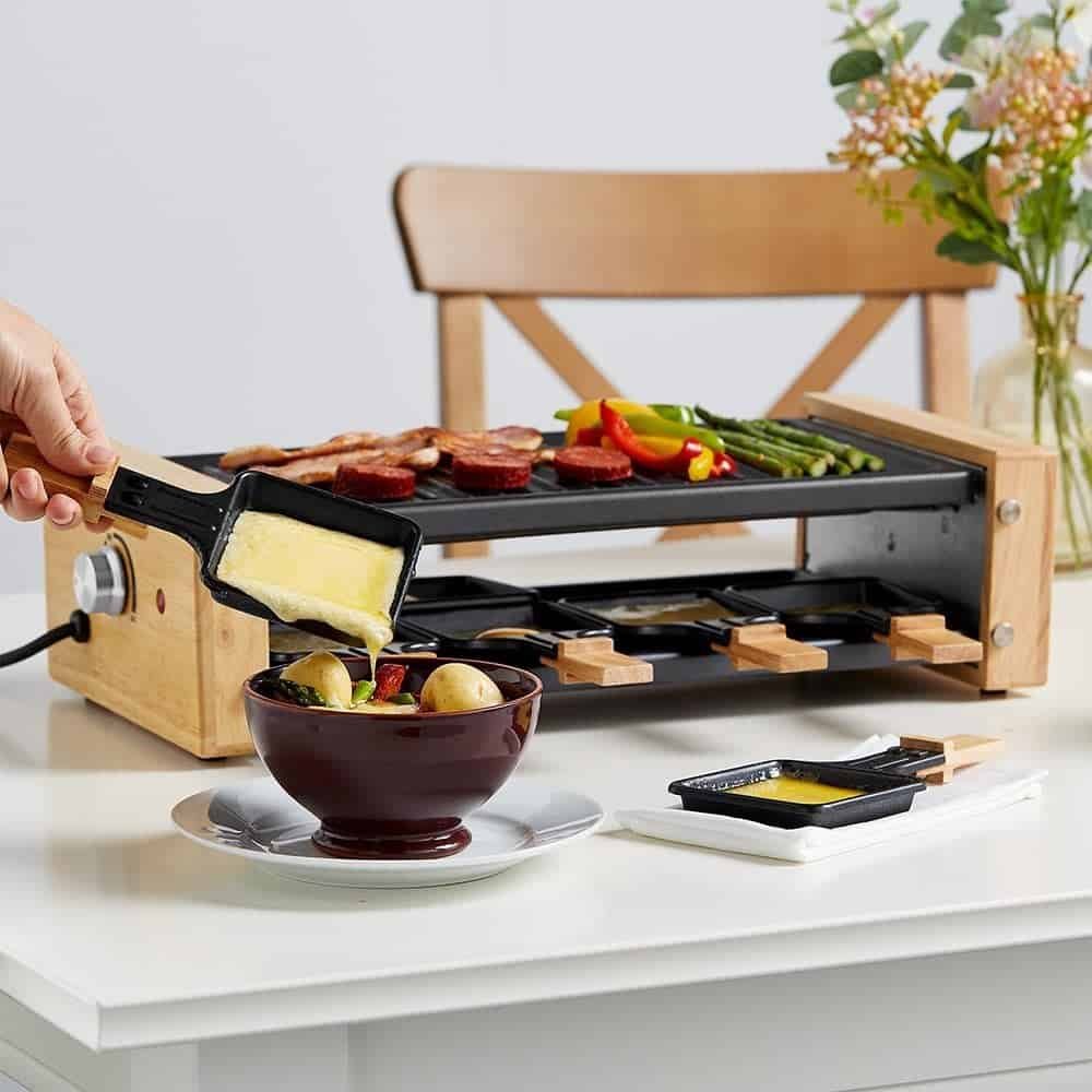 Raclette Grill with melted cheese being poured onto food