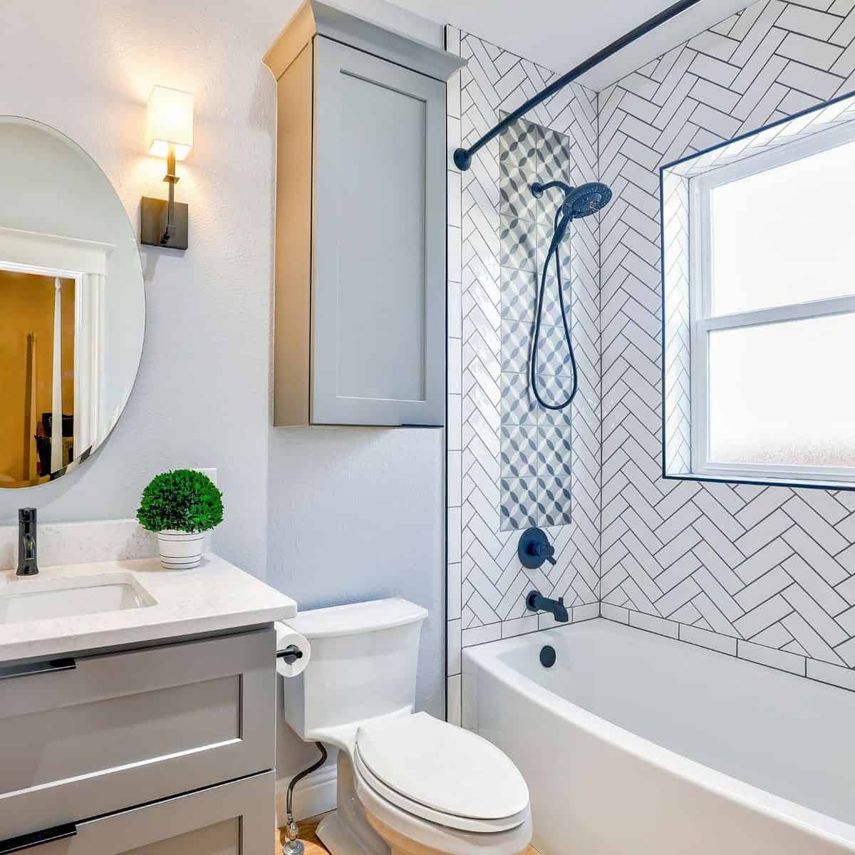 Bathroom with a sink on the left, toilet in the middle and a bath with a mixer shower over it and the rail for a shower curtain