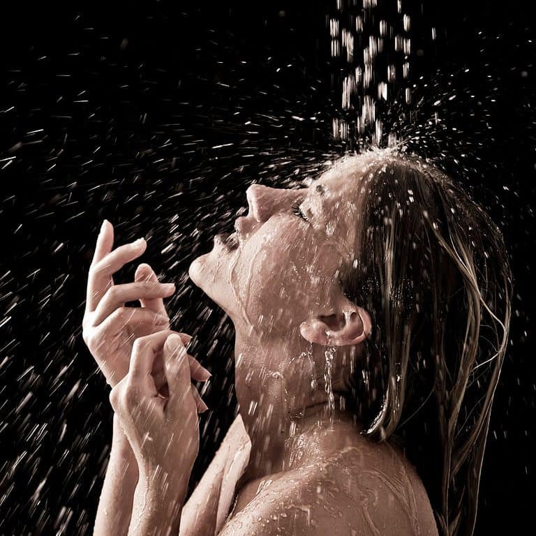 A lady enjoying water from a shower