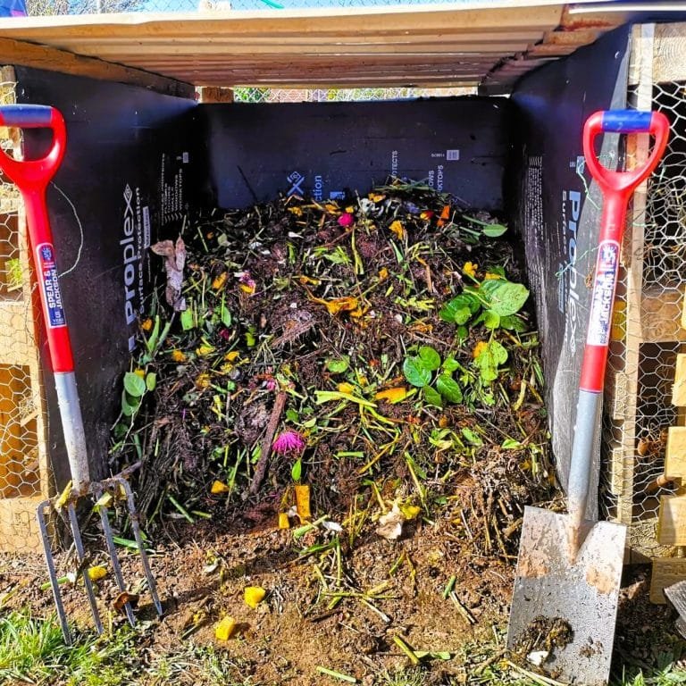 Compost pile and a pitch fork and shovel 748