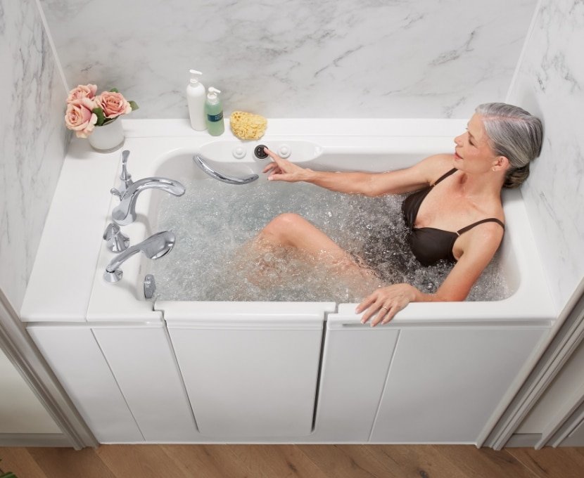 a photo of a woman enjoying a soak in a hydrotherapy walk-in tub